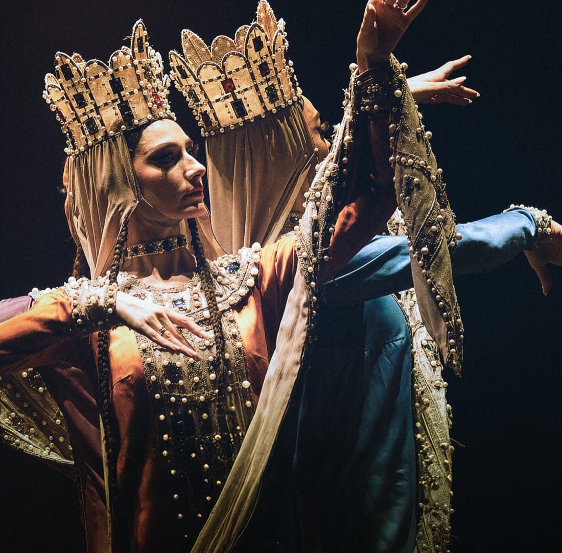 Dancers in gold crowns and embroidered court costumes